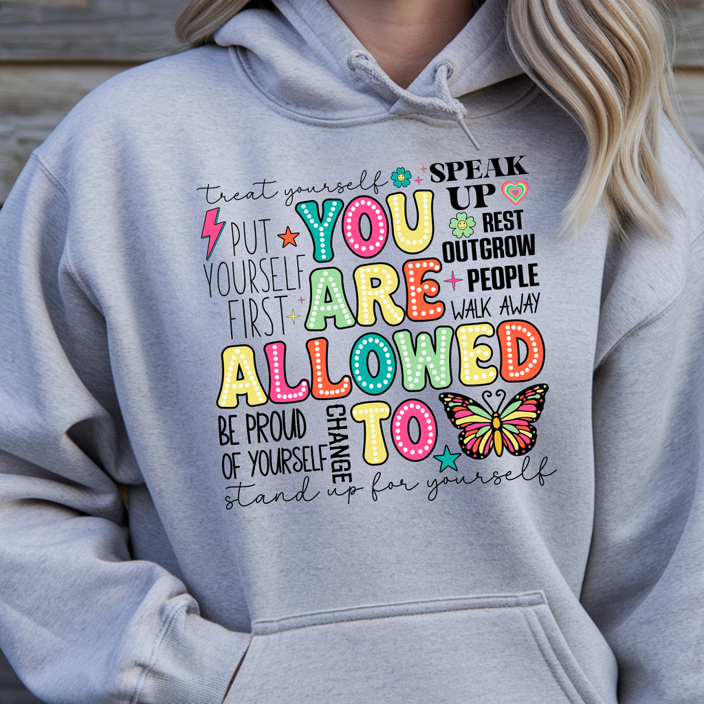 You Are Allowed To Hoodie inspirational affirmation hoodie with colorful letters and cheerful icons on a gray background.