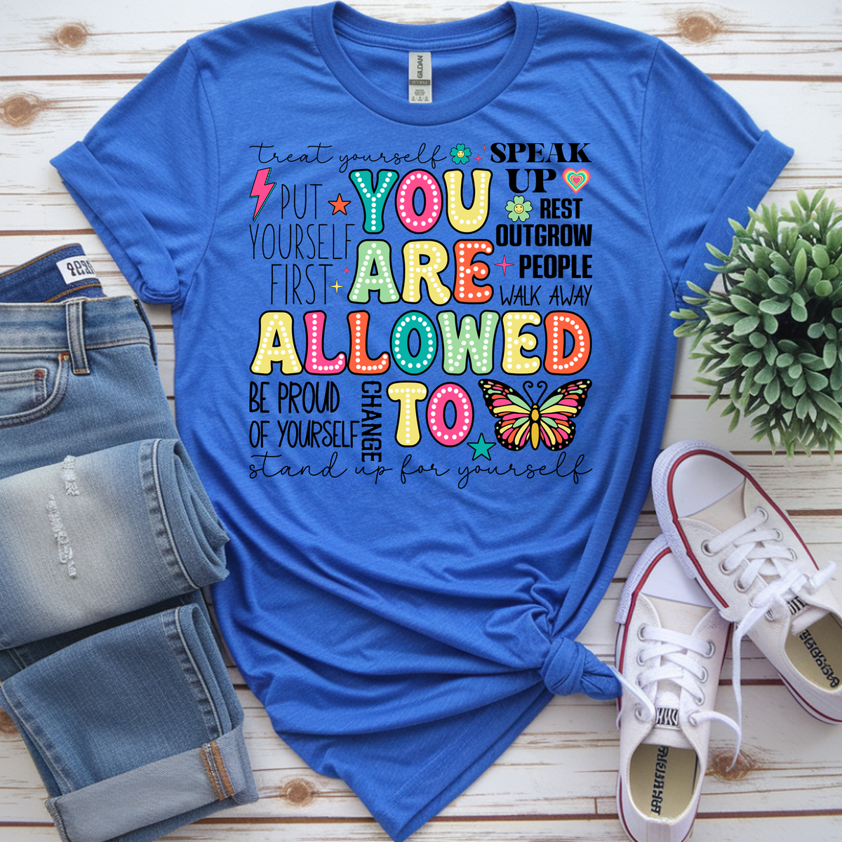 You Are Allowed To graphic t-shirt in blue with positive affirmations and a butterfly design, styled with jeans and sneakers.