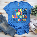 You Are Allowed To graphic t-shirt in blue with positive affirmations and colorful design, paired with denim shorts and sneakers.